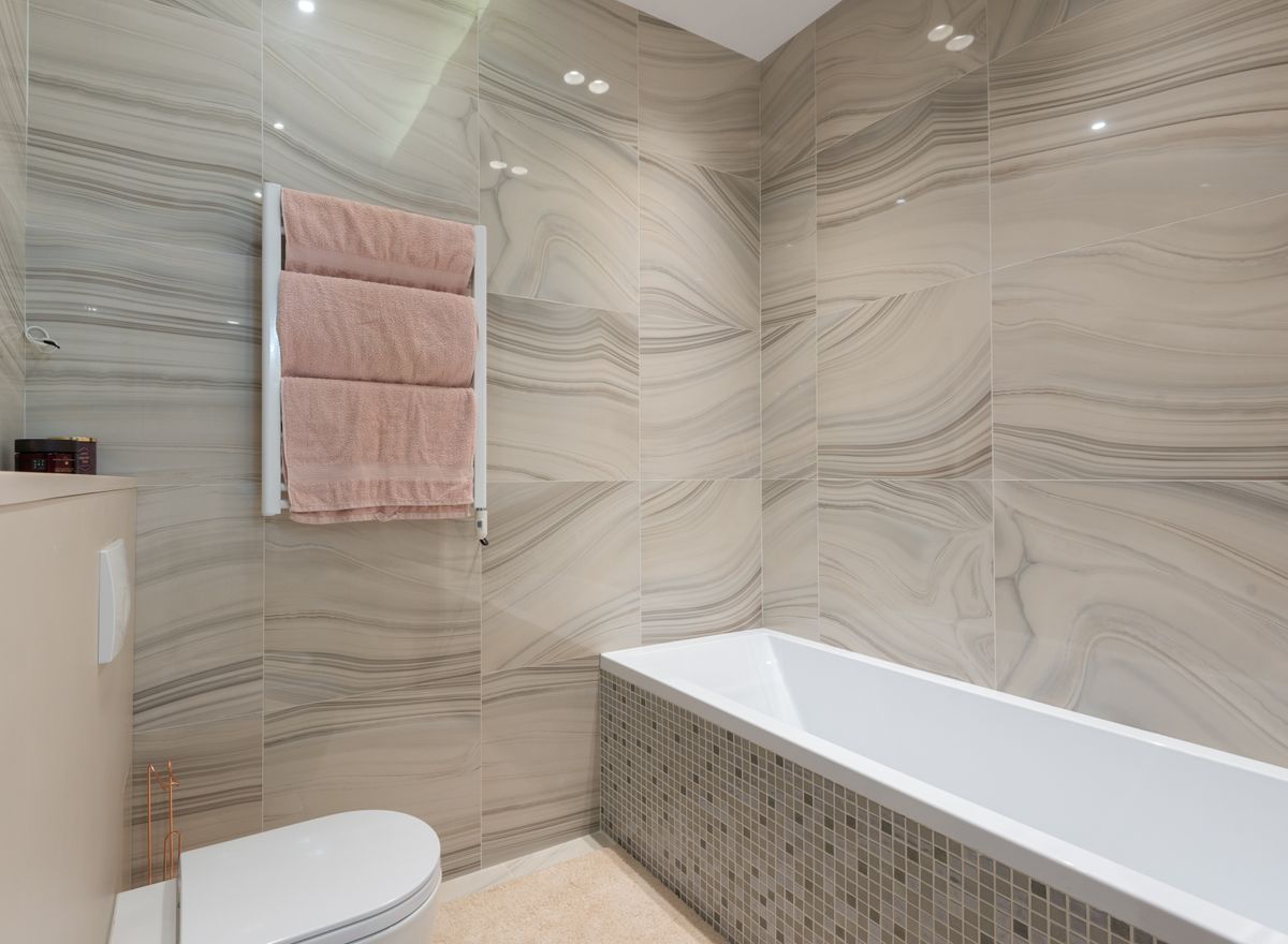 Bagno moderno con rivestimenti in marmo e vasca a mosaico